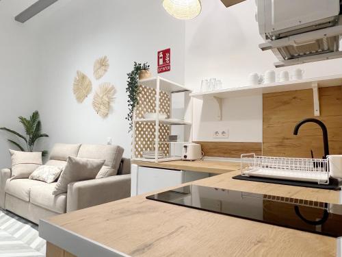 a kitchen and a living room with a couch at Encantador apartamento vigas de madera in Valencia