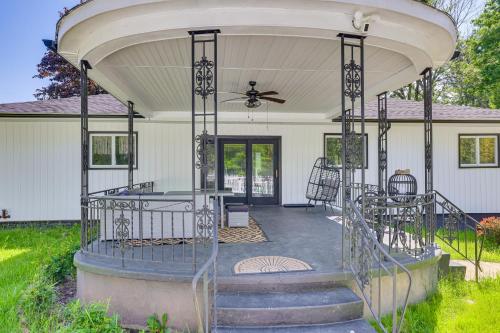 a covered porch of a white house with a ceiling at Outdoor Oasis Cresco Family Home with Hot Tub in Cresco