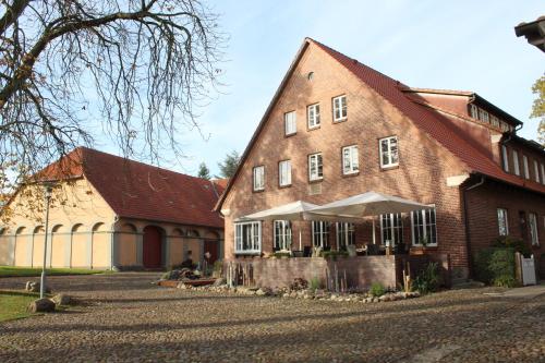a large brick building with a white tent in front of it at Landgasthof Wildwasser in Wolthausen
