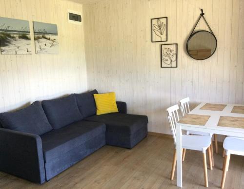 uma sala de estar com um sofá azul e uma mesa em Domki Selma em Władysławowo