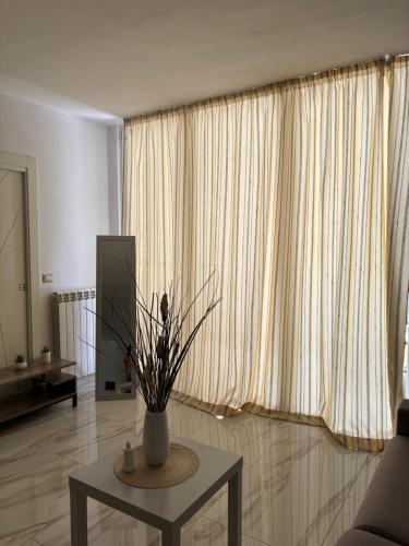 a living room with a table with a vase on it at Sol Casa in Cosenza