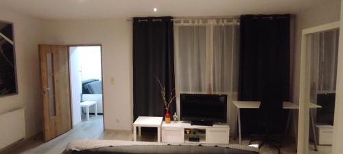 a living room with a tv and a couch at City Center Apartment 45m, 1 Bedroom and 1 Living Room with Kitchen plus Bathroom, a perfect Family Friendly Place or for Home Office and a longer Stay, a proper office desk with business chair provided, 100m from Market Square and Vistula River in Grudziądz