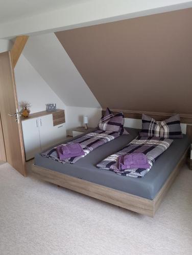 a bedroom with two beds with purple pillows at Landhaus Waldblick in Kritzow