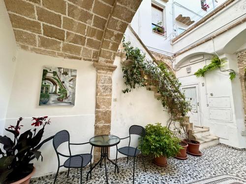 a patio with chairs and a table and plants at Palazzo Piccioli in Gallipoli