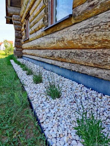 a building with a stone path next to a house at Klimatyczny dom z bali in Powidz
