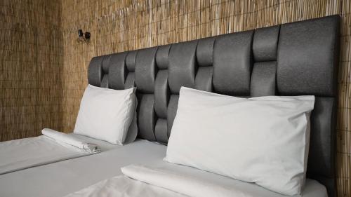 Una cama con dos almohadas blancas encima. en Mini Sofia en Sofía