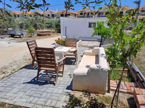 a patio with two chairs and a table and a building at George's apartment in Káto Almirí