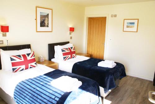 two beds in a hotel room with british towels at The Red Lion at Stiffkey in Stiffkey