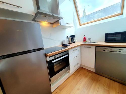 une cuisine avec un réfrigérateur en acier inoxydable et un évier dans l'établissement LE REVE BLEU I Neuf I Parking gratuit I Proche Mer I Wifi haut débit, à Saint-Brieuc