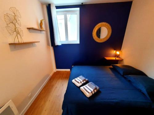 une chambre avec un lit bleu avec deux serviettes dessus dans l'établissement LE REVE BLEU I Neuf I Parking gratuit I Proche Mer I Wifi haut débit, à Saint-Brieuc