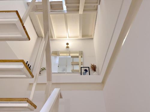 a staircase in a house with white walls and ceilings at Na Ekkamai Residence in Bangkok