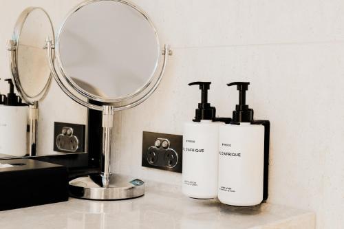 two soap dispensers sitting on a counter in front of a mirror at InterContinental Wellington by IHG in Wellington