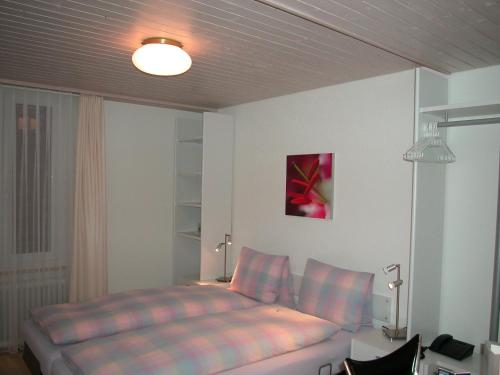 a bedroom with a bed and a desk with a lamp at Hotel Sporting in St. Gallen