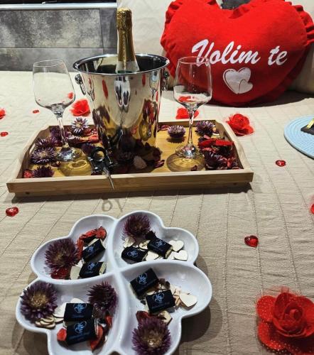 a table with a tray of food and wine glasses at You & Me spa apartment in Zlatibor