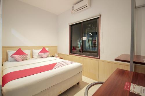 1 dormitorio con 1 cama, ventana y mesa en Super OYO Collection O 295 Grha Ciumbuleuit Guest House, en Bandung