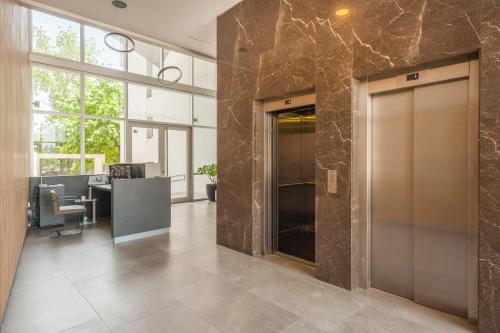 an office with a lobby with two elevators and a desk at Disfrutá Pilar Extraordinario Depto powered by Argenhost P28 in Manuel Alberti
