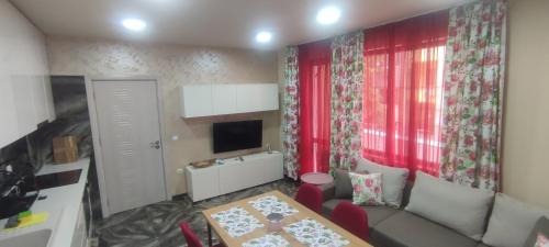 un soggiorno con divano e tavolo di Rose garden a Asenovgrad