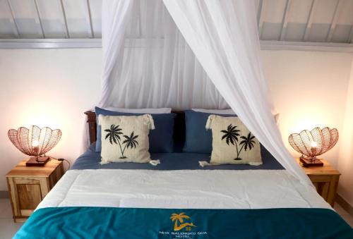 ein Schlafzimmer mit einem Himmelbett mit Palmen darauf in der Unterkunft New Balengkudua Hotel in Gili Air