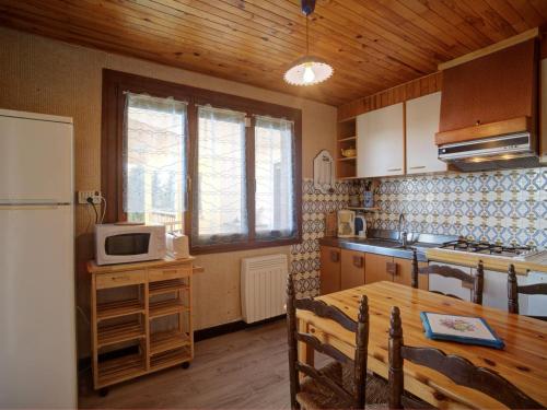 une petite cuisine avec une table et un réfrigérateur dans l'établissement Appartement spacieux 8 pers, 3 ch, proche pistes, parking privé, WIFI - FR-1-417-137, à La Toussuire