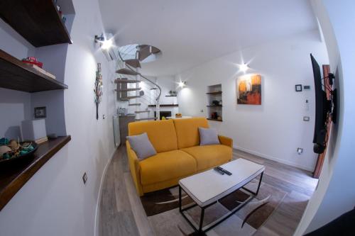 a living room with a yellow couch and a table at SIDORO Casa Vacanze in Bevagna
