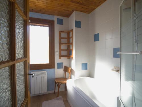 une salle de bain avec une baignoire, une chaise et une fenêtre dans l'établissement Appartement spacieux 8 pers, 3 ch, proche pistes, parking privé, WIFI - FR-1-417-137, à La Toussuire