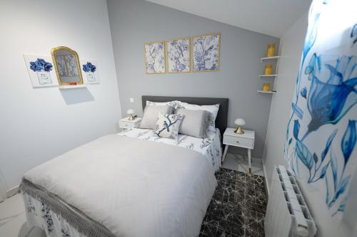 - une chambre dotée d'un lit avec des draps blancs et des touches de bleu dans l'établissement Appartement Royale 2 Pièces de 35 m2, à Noisy-le-Sec