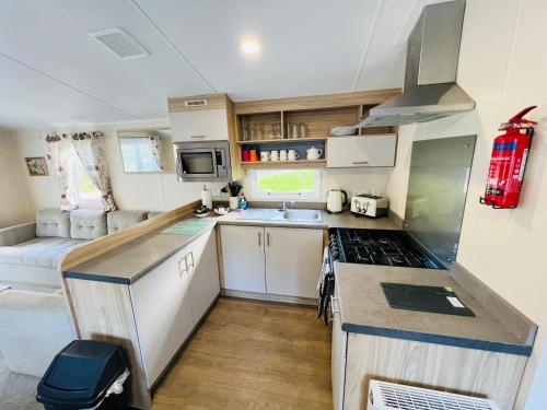 a small kitchen with a sink and a stove at 3 Bedroom Caravan LG17, Shanklin, Isle of Wight in Shanklin