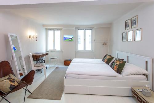 ein weißes Schlafzimmer mit einem weißen Bett und einem Schreibtisch in der Unterkunft Getreidegassen Appartements in Salzburg