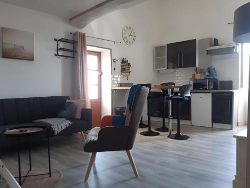 uma sala de estar com mesa e cadeiras e uma cozinha em Gîte des Bujours em Saint-Bris-des-Bois