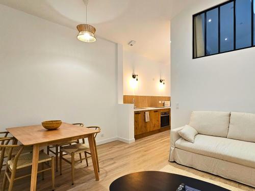 un salon avec une table et un canapé dans l'établissement Appartement Le Bali, charmant et paisible !, à Cholet