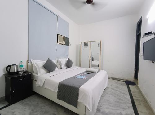 1 dormitorio con 1 cama grande y espejo en Hotel Hauz Khas Fort View en Nueva Delhi