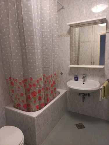 a bathroom with a sink and a shower curtain at Apartments & Rooms Karmen in Portorož