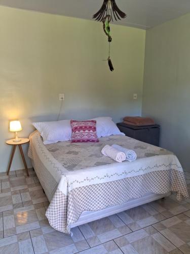 um quarto com uma cama com duas toalhas em EcoPousada - Sitio Aborigene em São Lourenço do Oeste