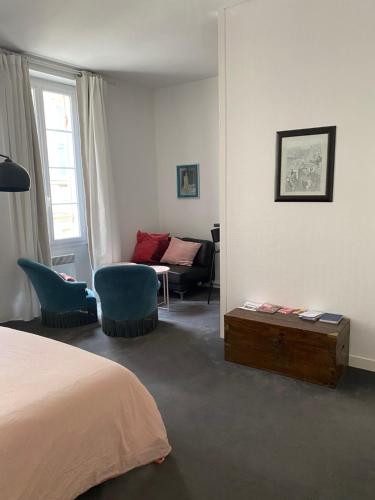 a bedroom with a bed and a chair and a couch at studio de 30 m2 dans le triangle d'or de Bordeaux in Bordeaux