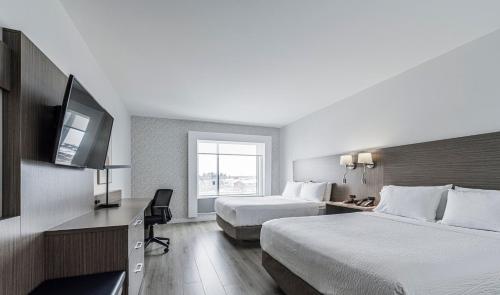 Cette chambre comprend deux lits et une télévision. dans l'établissement Holiday Inn Express Hotel & Suites Saint - Hyacinthe, an IHG Hotel, à Saint-Hyacinthe