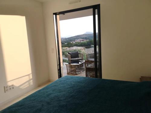 una camera da letto con un letto e una porta scorrevole in vetro di Magnifique T2 neuf à 100 m de la plage d'agosta a Albitreccia