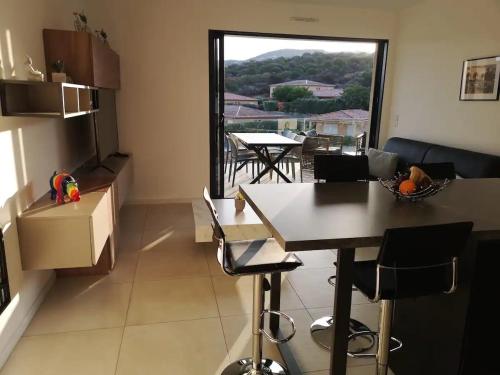 una cucina e una sala da pranzo con tavolo e finestra di Magnifique T2 neuf à 100 m de la plage d'agosta a Albitreccia