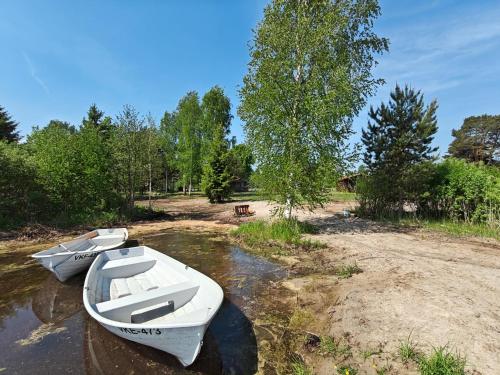 two white boats sitting in the water in a river at Kalmaküla kämpingud in Kalmaküla