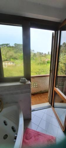 a bathroom with a bath tub and a window at Casa Primetta in Camaiore