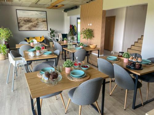 uma sala de jantar com mesas e cadeiras de madeira em Między Wodami em Międzywodzie