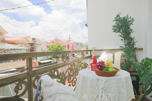 a table with a basket of fruit on a balcony at Huong Anh DaLat Palace in Da Lat