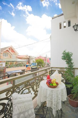 a table with a bowl of fruit on a balcony at Huong Anh DaLat Palace in Da Lat