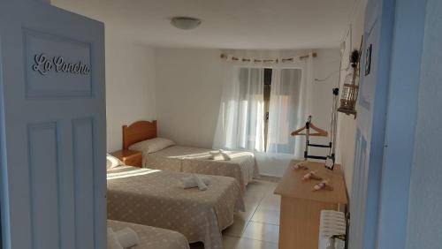 a hotel room with two beds and a desk at Casadidoru in Mansilla de las Mulas