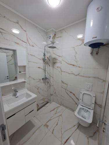 Baño blanco con lavabo y aseo en KAN i DZAN, en Ulcinj