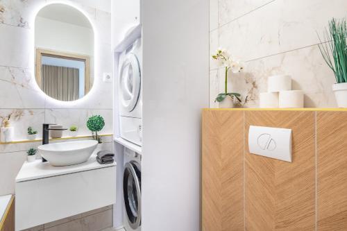 a bathroom with a sink and a washing machine at Cozy studio at residential area - free street parking in Budapest