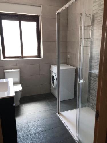 a bathroom with a shower and a washing machine at Casa Intramuros Zamora in Zamora