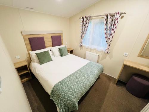 a bedroom with a large white bed and a window at 3 Bedroom Caravan LG17, Shanklin, Isle of Wight in Shanklin