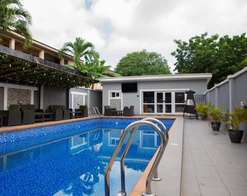 a swimming pool in front of a house at A's Hospitality in Ikeja