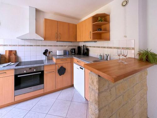 cocina con armarios de madera y encimera de madera en Appartement calme, parking privé, en Schiltigheim