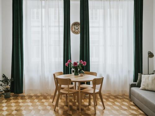 a dining room table with chairs and a vase of flowers at S18 Apartments in Kraków